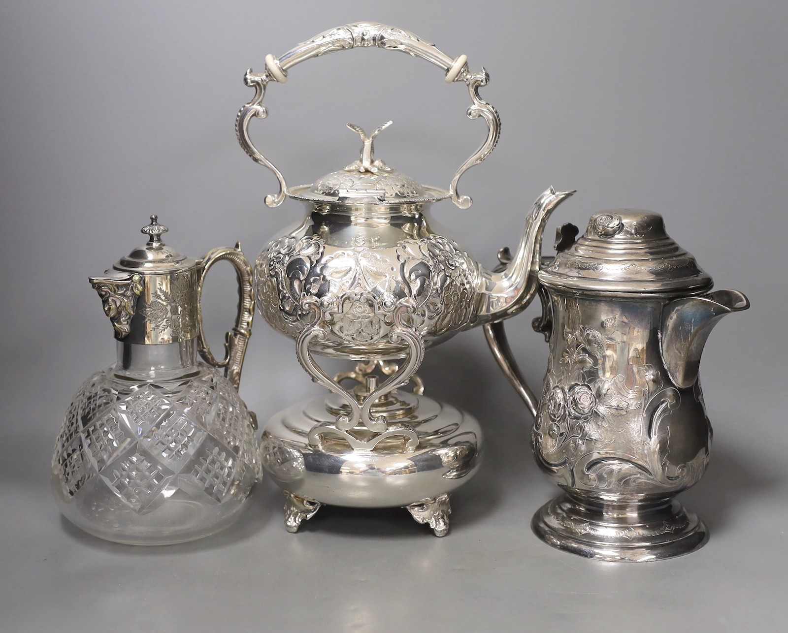 A silver plated tea kettle, burner and stand, ceramic insulators, 33 cm high a mounted claret jug and a tankard